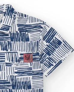Chemise blanche pour garçon avec imprimé géométrique bleu et poche décorative.