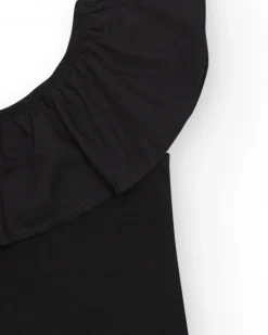 Top pour fille en noir avec design asymétrique et clous métalliques.